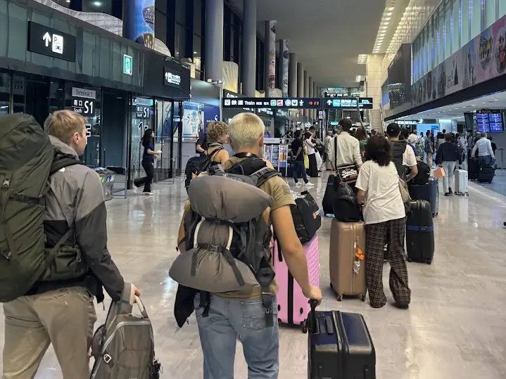 Rejsende fra holdet går gennem lufthavnen med kufferter efter landing